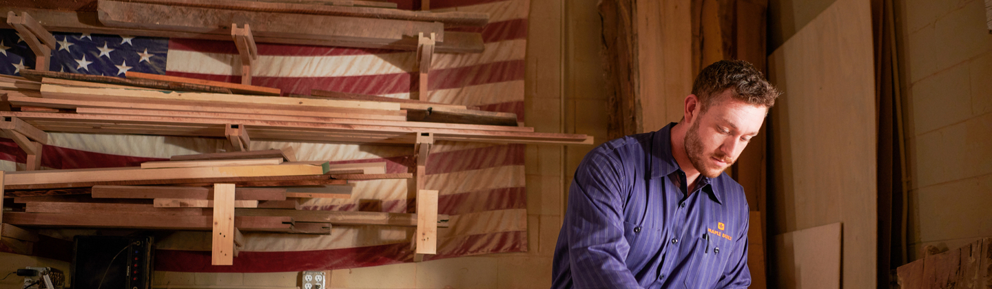 Man wearing a custom workshirt while working in his wood shop